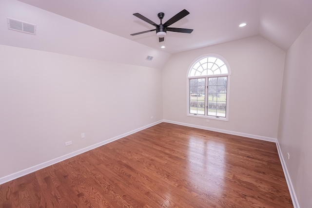 empty room featuring ceiling fan, lofted ceiling, and dark wood-type flooring