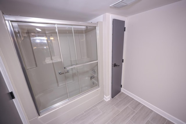 bathroom with wood-type flooring and enclosed tub / shower combo