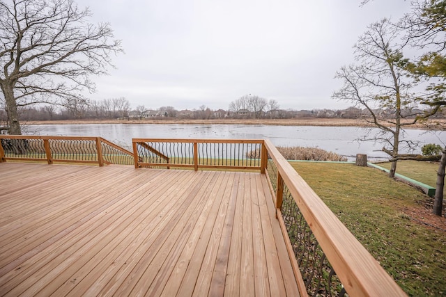 wooden terrace featuring a water view and a lawn