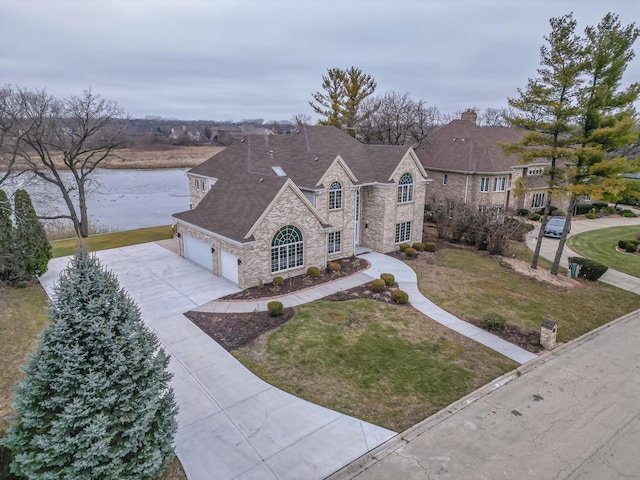 view of front of property with a garage, a water view, and a front yard