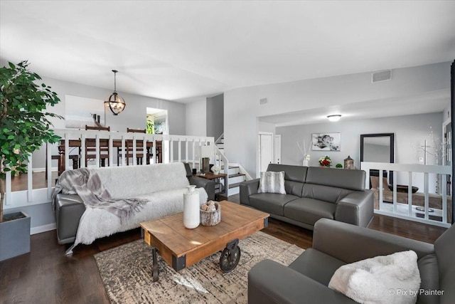 living room with dark wood-type flooring and an inviting chandelier