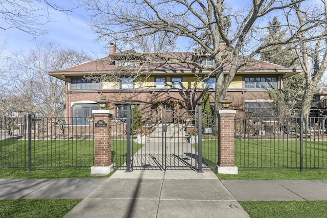 view of front of property featuring a fenced front yard, a gate, a front lawn, and brick siding