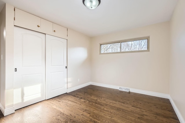 unfurnished bedroom featuring wood-type flooring and a closet