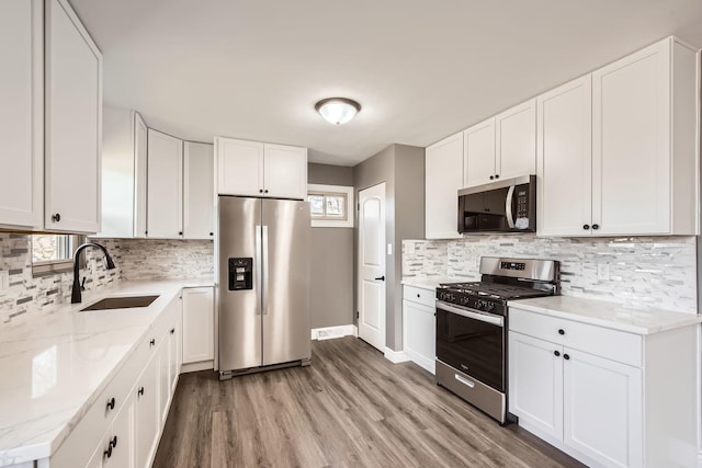 kitchen featuring sink, white cabinets, stainless steel appliances, and light wood-type flooring