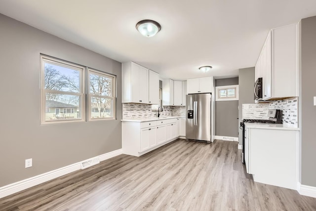 kitchen featuring white cabinets, light wood-type flooring, and stainless steel appliances