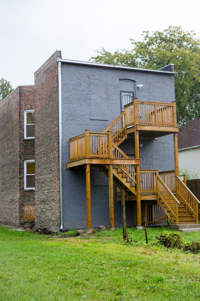 back of house featuring a wooden deck and a yard