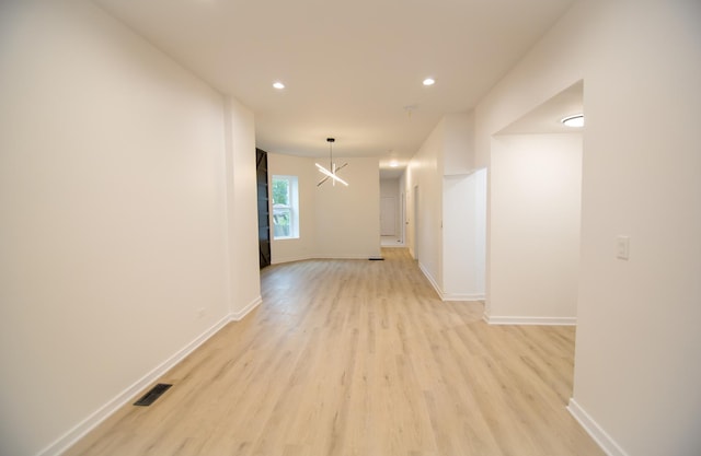 hall with a chandelier and light hardwood / wood-style flooring