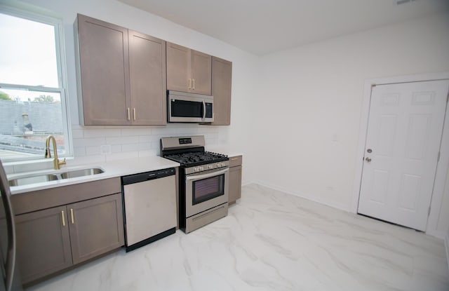 kitchen with appliances with stainless steel finishes, backsplash, and sink