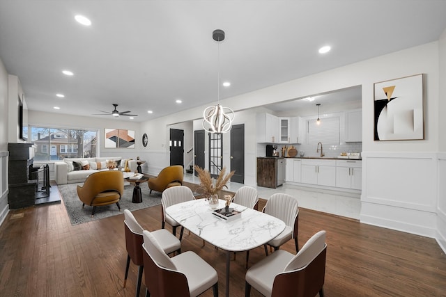 dining area with ceiling fan, sink, and dark hardwood / wood-style floors