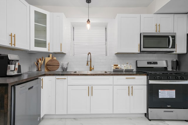 kitchen with decorative backsplash, sink, white cabinetry, and stainless steel appliances