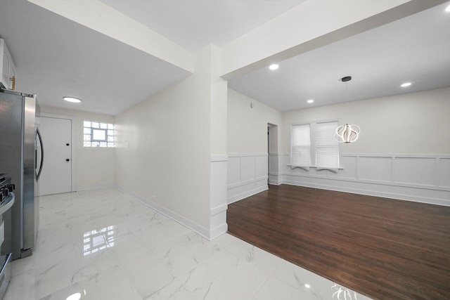 interior space featuring stainless steel refrigerator, stove, and hanging light fixtures