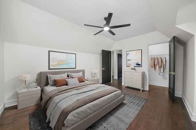 bedroom with a walk in closet, ceiling fan, dark wood-type flooring, a closet, and lofted ceiling