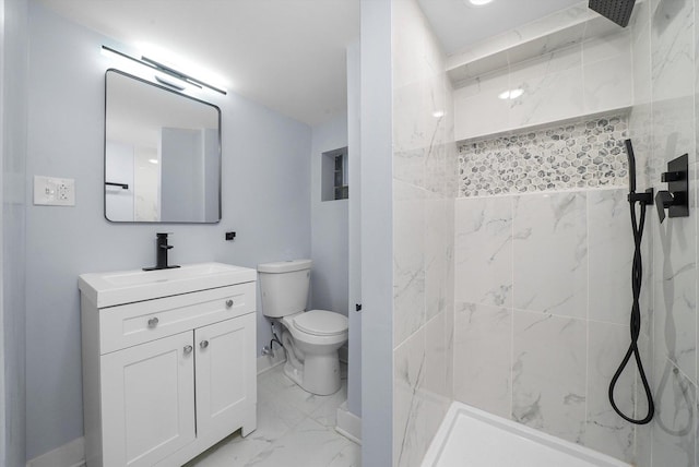 bathroom featuring vanity, toilet, and tiled shower