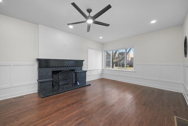 unfurnished living room featuring ceiling fan and dark wood-type flooring