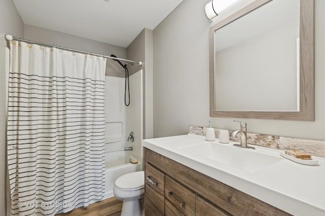 full bathroom with hardwood / wood-style floors, vanity, shower / tub combo, and toilet