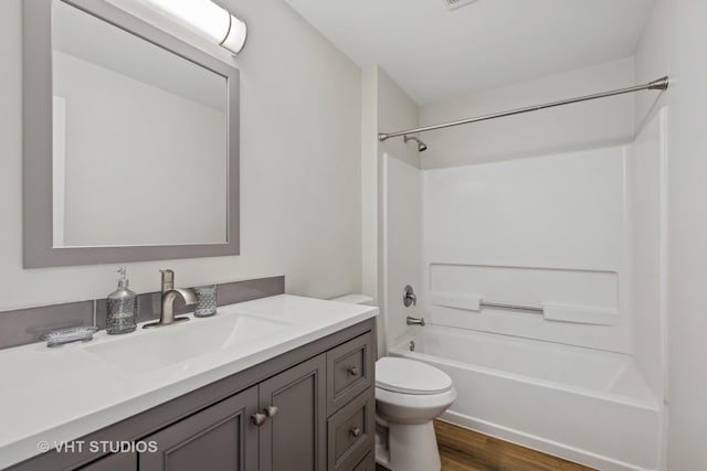 full bathroom featuring hardwood / wood-style floors, vanity, shower / bath combination, and toilet