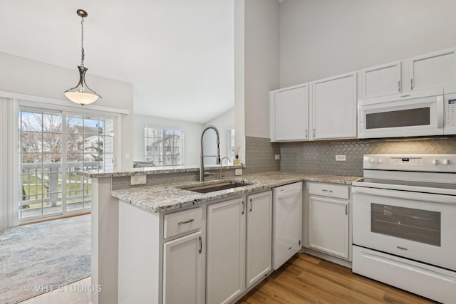 kitchen with white cabinets, white appliances, kitchen peninsula, and light hardwood / wood-style flooring