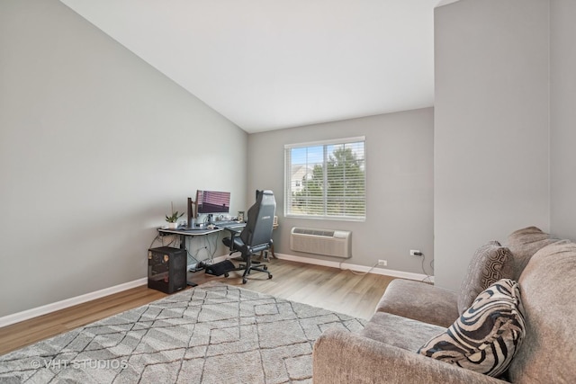 home office featuring hardwood / wood-style flooring, a wall mounted air conditioner, and lofted ceiling