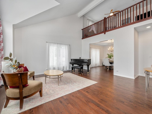 interior space featuring beamed ceiling, dark hardwood / wood-style flooring, ceiling fan with notable chandelier, and a wealth of natural light