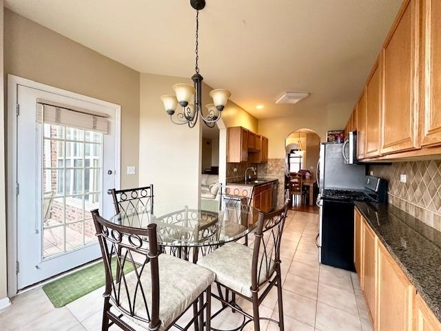 dining area featuring a chandelier and light tile patterned floors