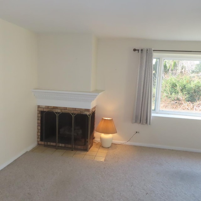 unfurnished living room featuring light carpet and a brick fireplace