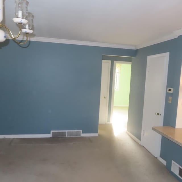 spare room with a notable chandelier and ornamental molding