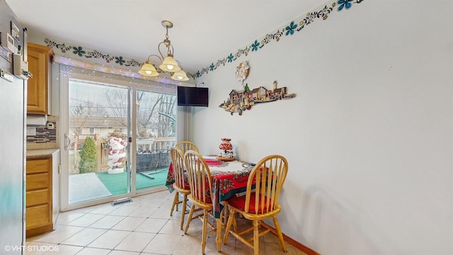 tiled dining space with an inviting chandelier