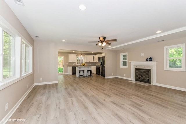 unfurnished living room featuring light hardwood / wood-style flooring and plenty of natural light