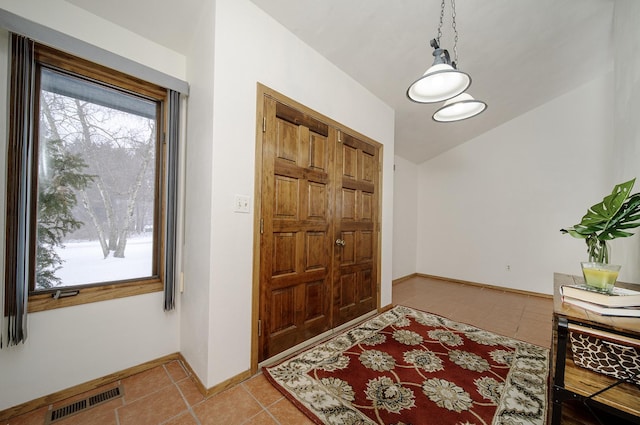 tiled entryway featuring lofted ceiling