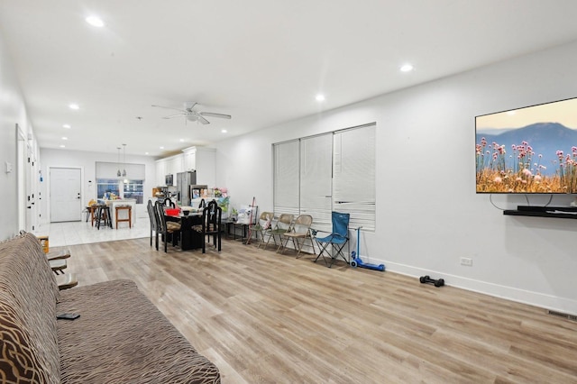 living room with ceiling fan and light hardwood / wood-style floors