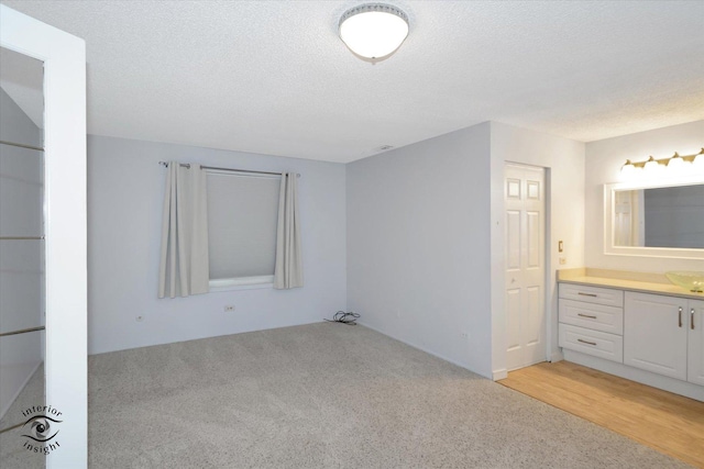 interior space featuring light wood-type flooring and a textured ceiling