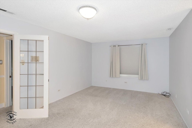 carpeted spare room with a textured ceiling