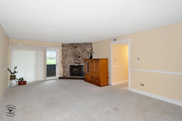 unfurnished living room with a fireplace, a textured ceiling, and light colored carpet