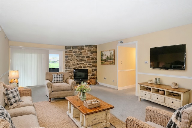 living room featuring a stone fireplace and light carpet