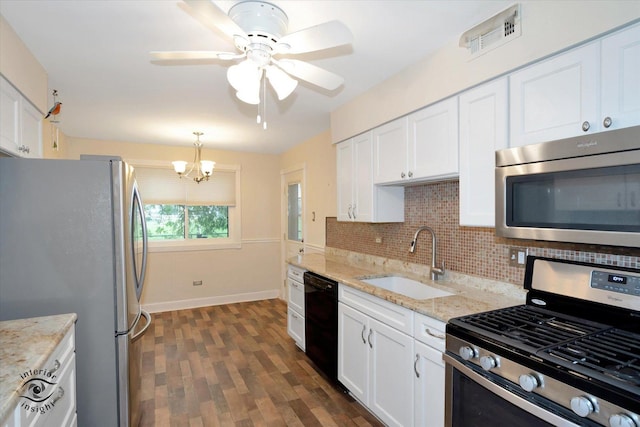 kitchen featuring backsplash, white cabinets, hanging light fixtures, sink, and appliances with stainless steel finishes