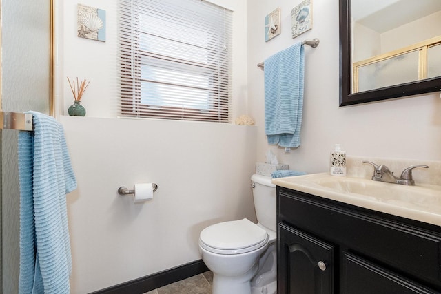 bathroom featuring tile patterned floors, toilet, vanity, and an enclosed shower