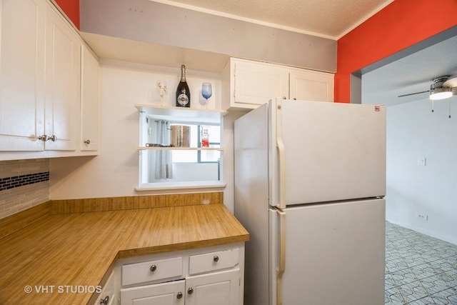 kitchen with freestanding refrigerator, a textured ceiling, white cabinets, and open shelves