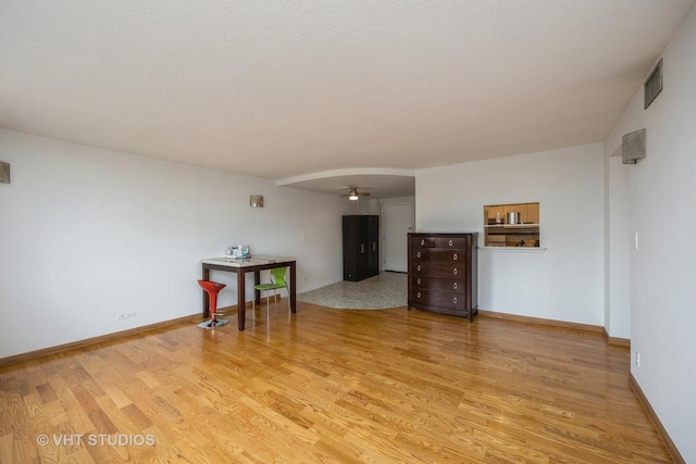 spare room with a ceiling fan, baseboards, visible vents, and light wood-type flooring