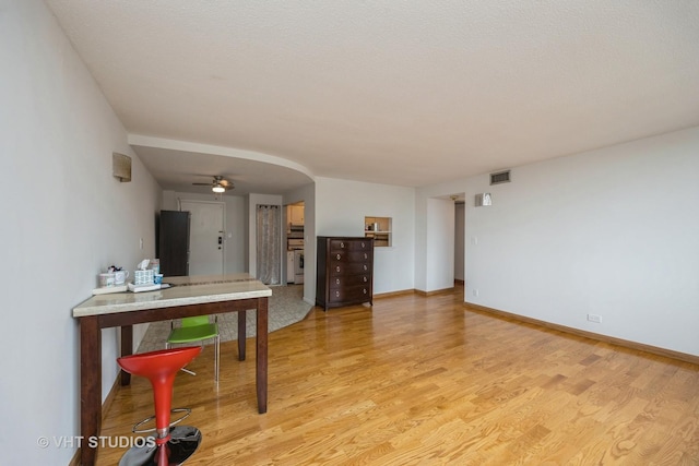 living room with light wood-style flooring, baseboards, and visible vents