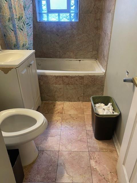 full bathroom with vanity, toilet, and tiled shower / bath