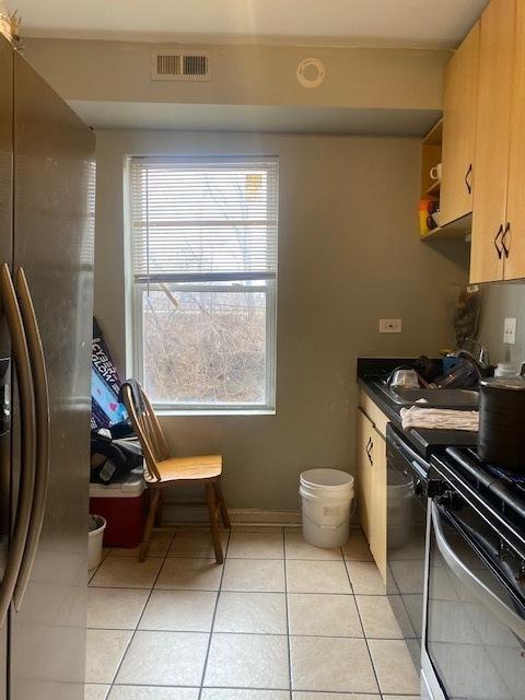 kitchen featuring light tile patterned floors, stainless steel appliances, and sink