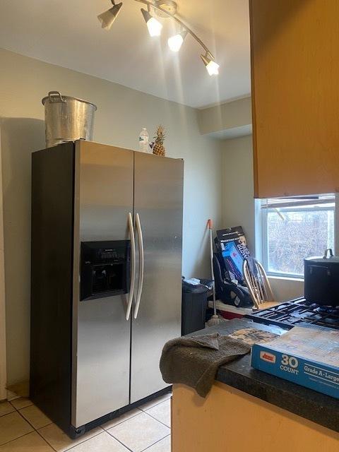 kitchen featuring stainless steel fridge, ceiling fan, and light tile patterned flooring