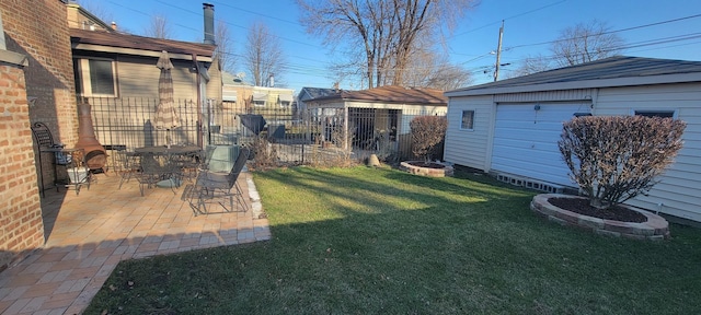 view of yard with a patio area, an outbuilding, and a garage