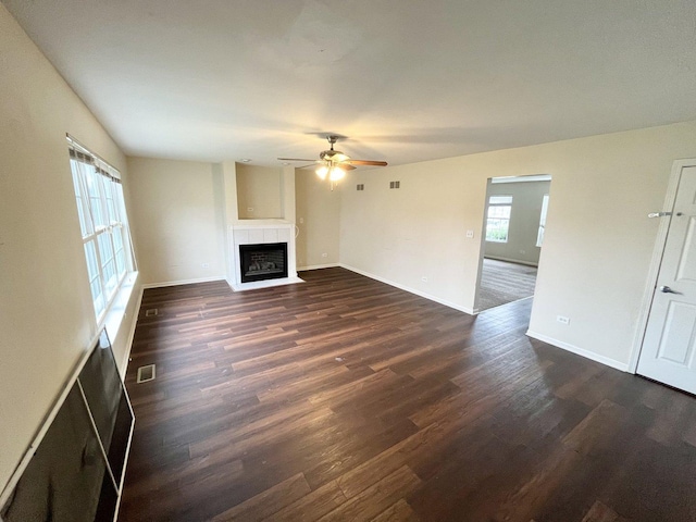 unfurnished living room featuring ceiling fan and dark wood-type flooring