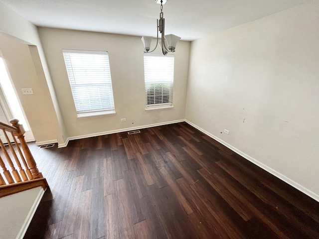 unfurnished dining area with a chandelier and dark wood-type flooring