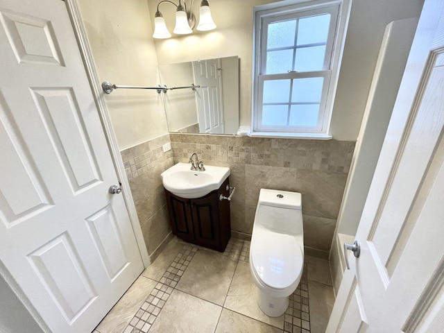 bathroom with tile patterned flooring, vanity, a chandelier, and tile walls