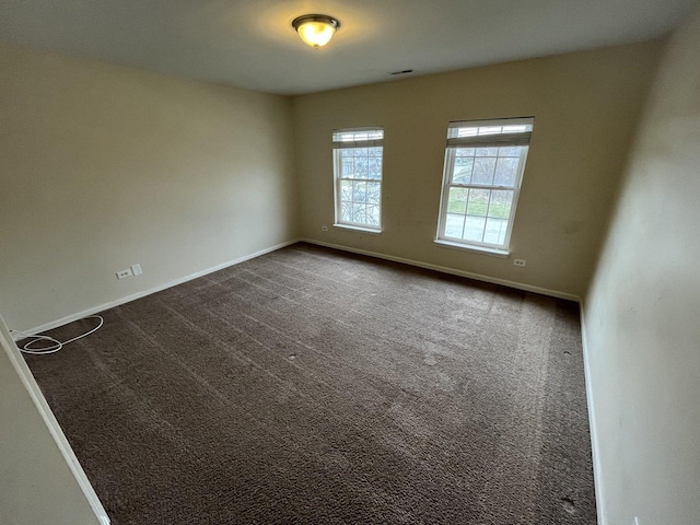 spare room with dark carpet