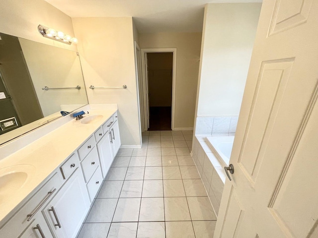 bathroom featuring tile patterned floors, vanity, and tiled bath