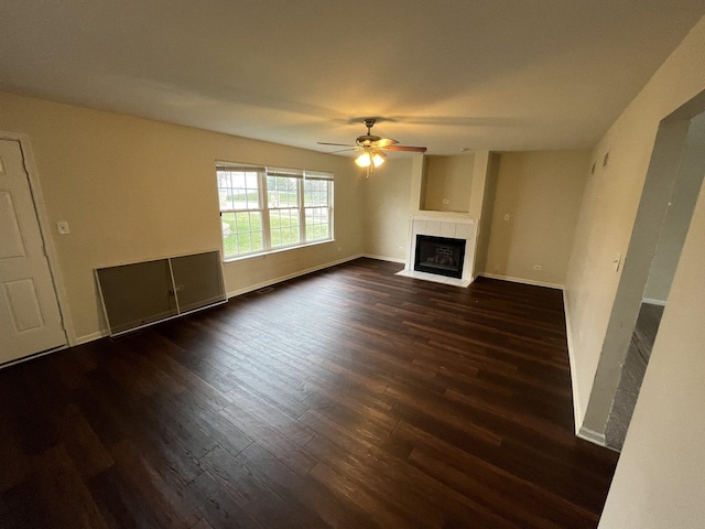 unfurnished living room with ceiling fan and dark wood-type flooring