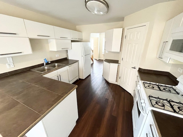 kitchen featuring white appliances, white cabinetry, dark wood-type flooring, and sink